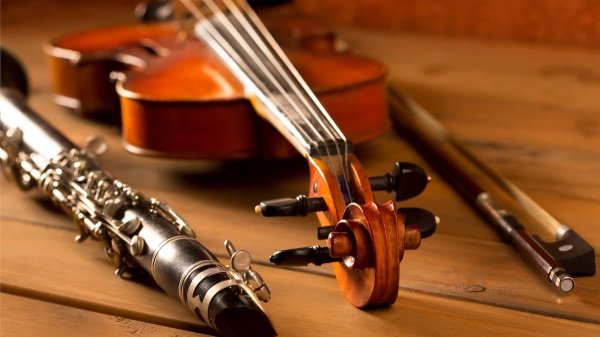 Abbildung einer Geige und Klarinette auf einen Holztisch.
