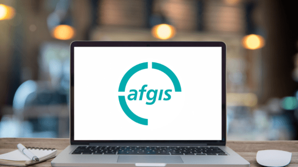 Aufgeklappter Laptop mit afgis Logo vor stimmungsvollem Licht im Hintergrund