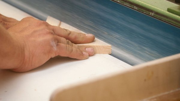 Blick auf die Hand während Holzarbeiten in einer Tischlerei.