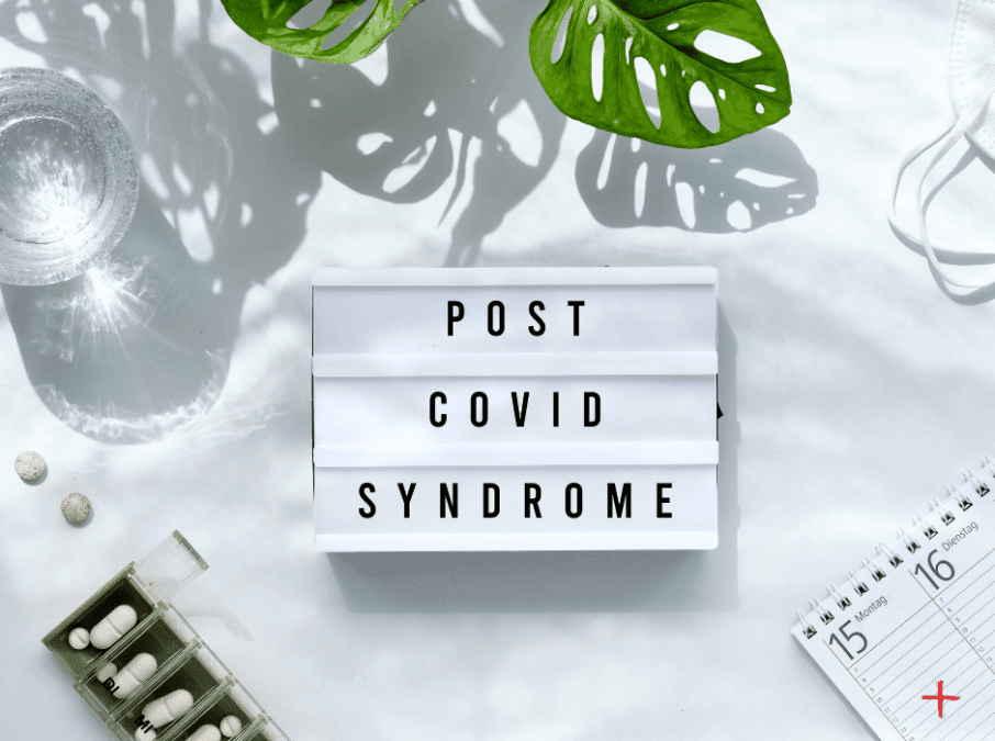 Schriftzug Post Covid Syndrome auf weißem Hintergrund mit Medikamenten, Wasserglas, Kalender.
