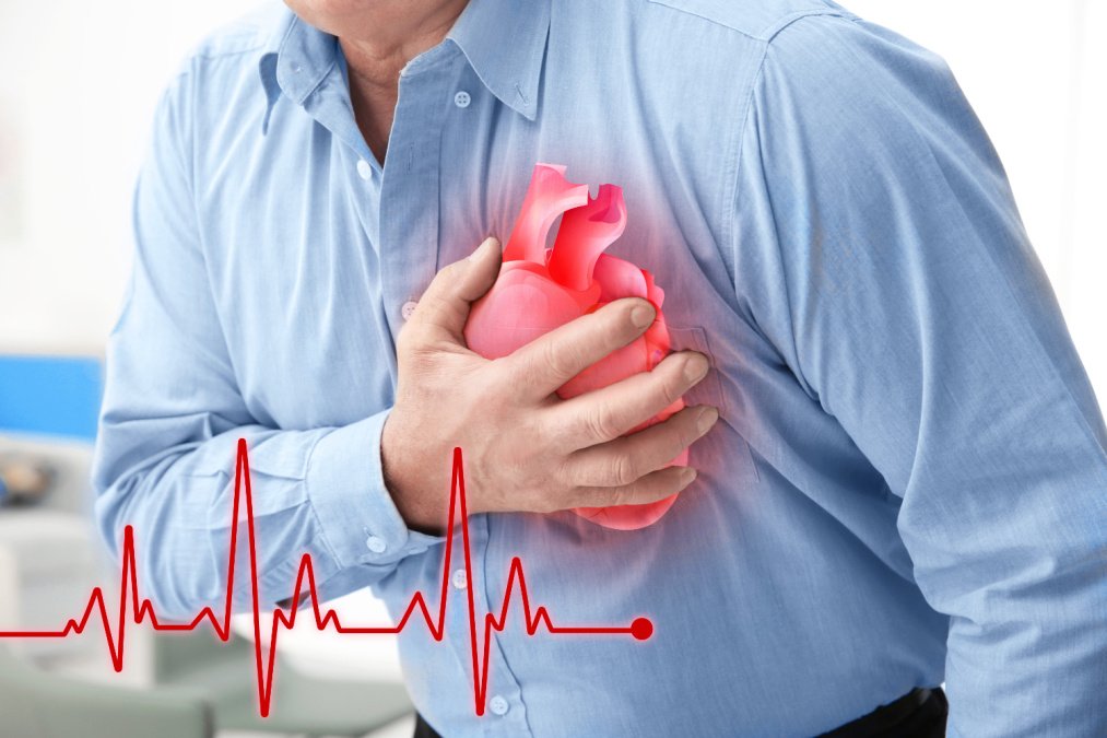 Mann hält sich die Brust auf Höhe des Herzens aufgrund von Schmerzen.