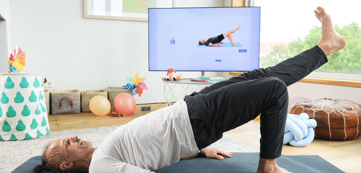 Patient macht digitale T-Rena Übungen vor dem Fernseher