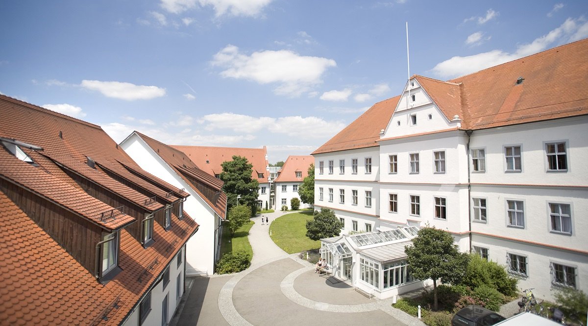 Hauptgebäude der Schlossklinik Bad Buchau, weißer Altbau mit rotem Dach