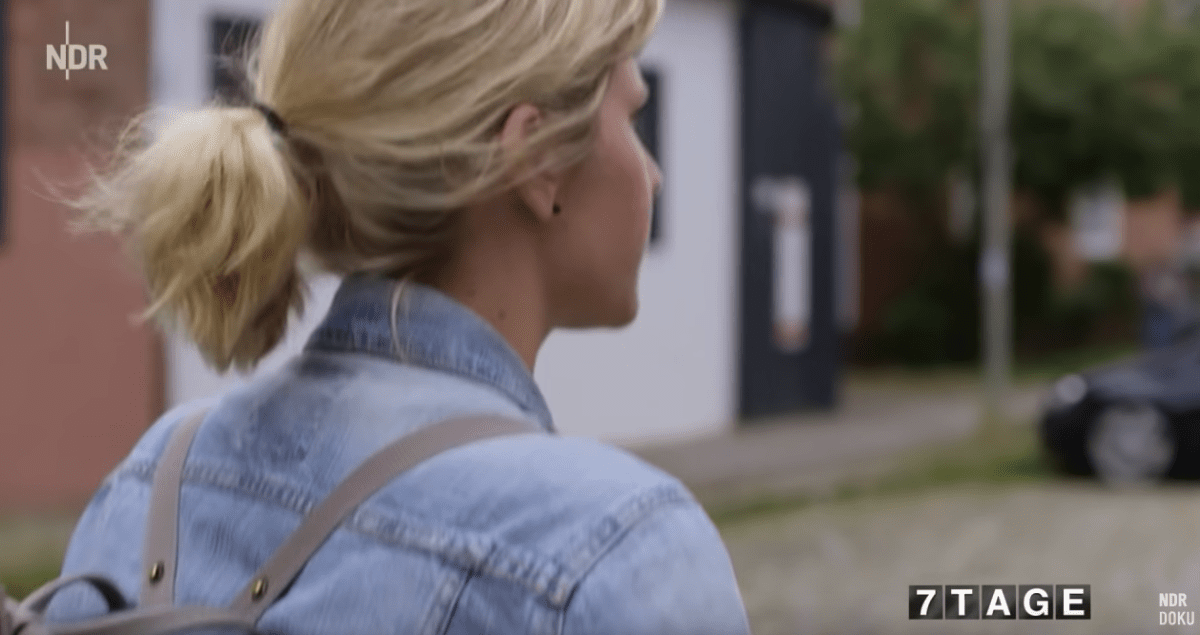 Blonde Frau mit zurückgebundenen blonden Haaren in Jeansjacke, halbes Profil, NDR-Logo